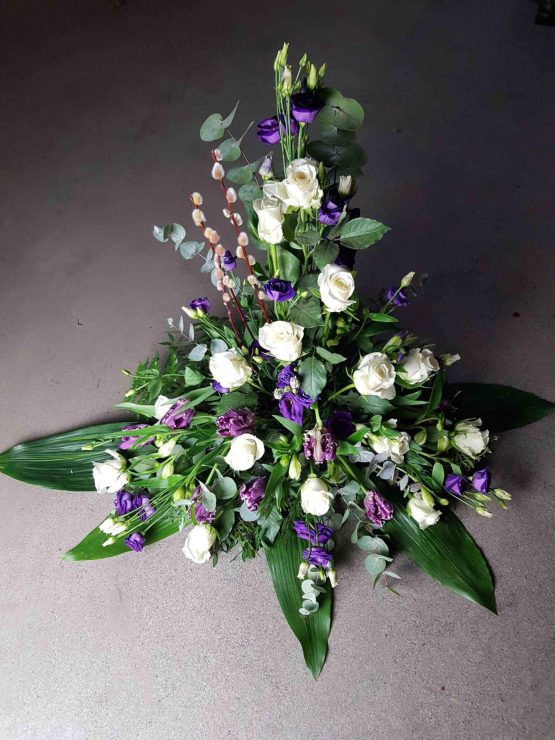 hög dekoration till begravning i lila och vitt