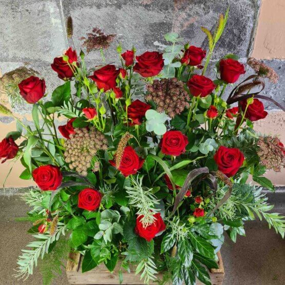 Dekoration till begravning med röda rosor