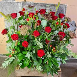 Hög dekoration med röda rosor till begravning
